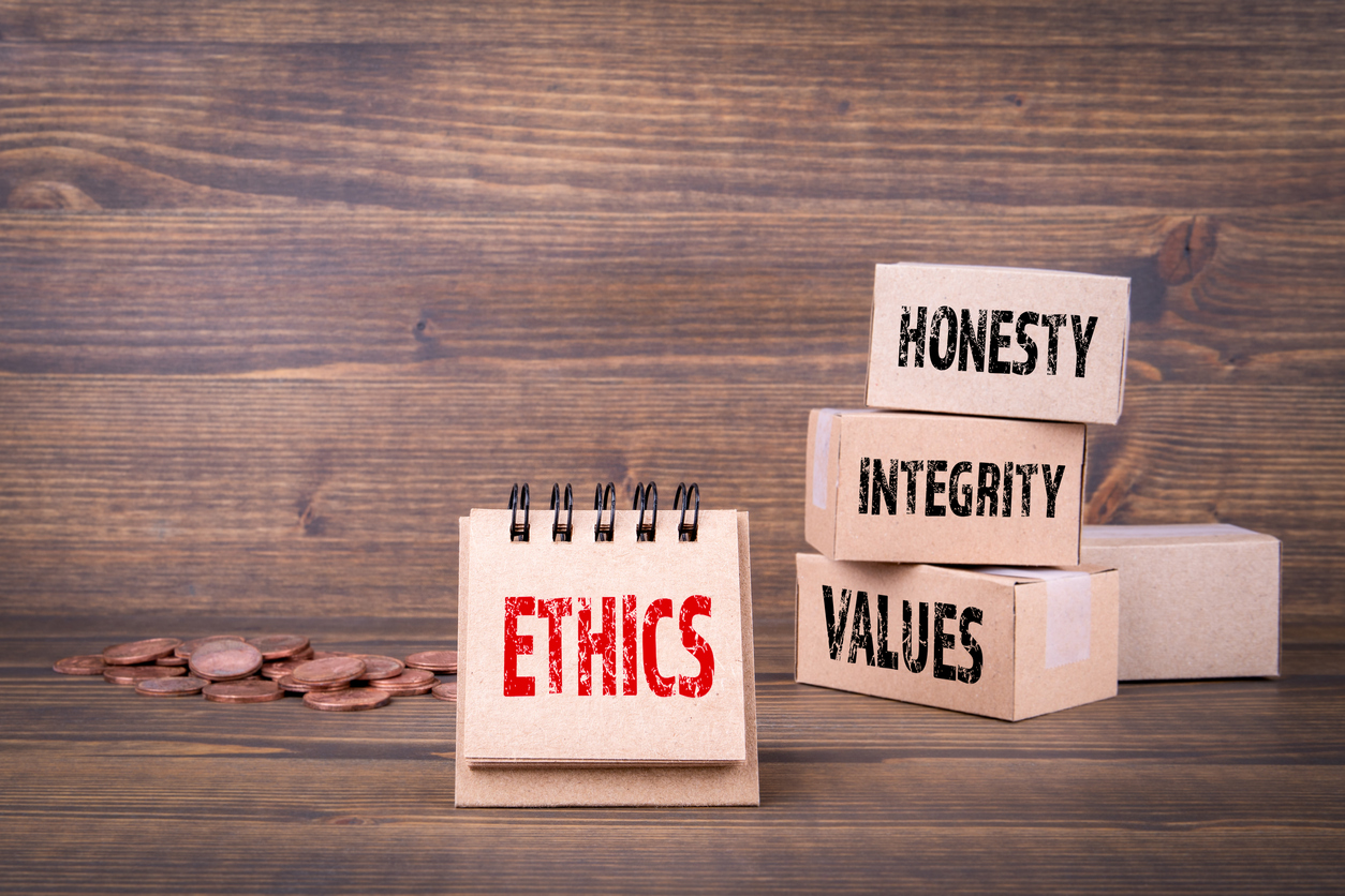  An illustration of boxes labeled with the words 'honesty', 'integrity', and 'values' next to a notebook labeled with the word 'ethics' in red, with some pennies on the table in the foreground, representing the search query 'Ethics and laws governing witchcraft and black magic practices'.